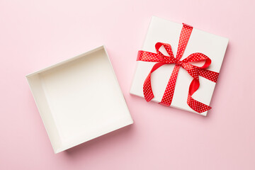 Open gift box on color background, top view