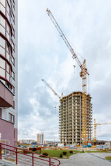 Fototapeta premium Crane and building under construction against blue sky