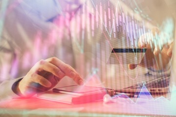 Double exposure of man hands holding a credit card and Forex graph drawing. Stock trading and digital fintech in Internet E-commerce concept.