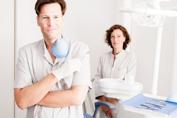 Fototapeta premium Dentists portrait in uniform standing in dentist office looking at camera 