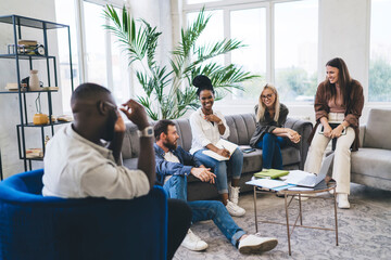 Happy diverse people sitting together and having conversation in modern room