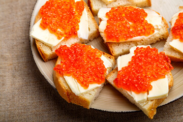 Canape with red trout and butter in a plate on a gray table.close-up.