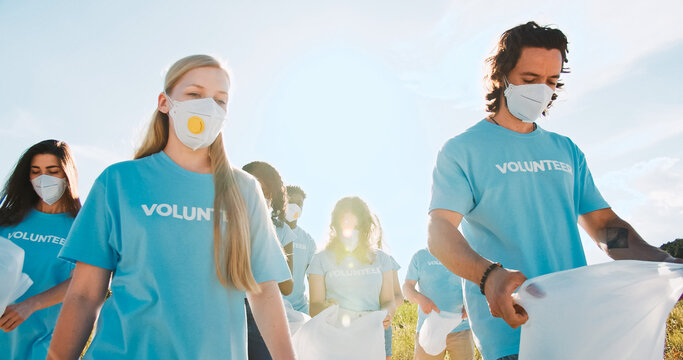 A Group Of Volunteers Going In Medical Masks With Garbage, Trash Bags To Pick Up Plastic Bottles, Waste.