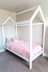 DIY child house style bed frame painted white with geometric accent wall