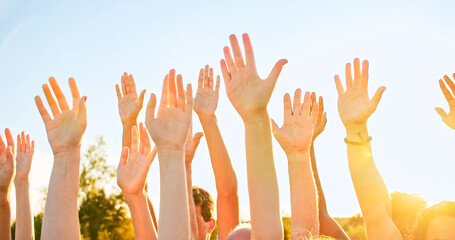 A group of happy eco activists putting, raising hands up to the sky. Friendship, teamwork, volunteering concept.