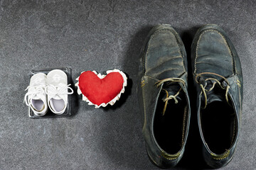 Daddy's boots and baby's shoes with heart, fathers day concept
