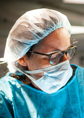 Surgical nurse assisting a surgeon in the treatment of a traumatic brain injury