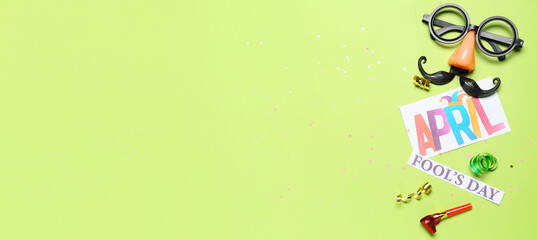 Obraz premium Text APRIL FOOL'S DAY and party decor on green background with space for text