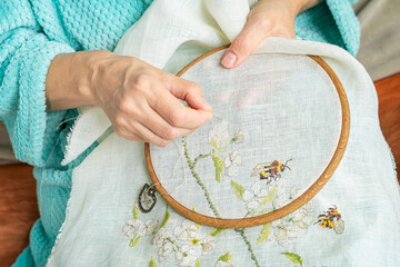 Hands embroidery, woman hands with fabric and wooden embroidery hoop