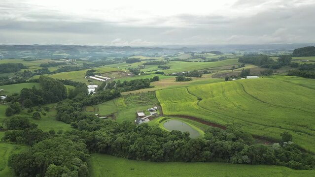 Aerial view of green fields in a cloudy day. South of Brazil. 4K.