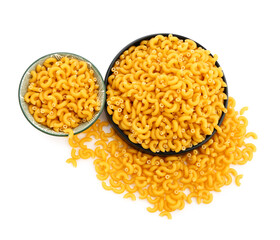 Plates of raw elbow pasta isolated on white background