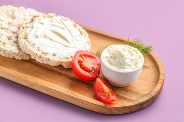 Wooden plate of tasty crispbreads with cream cheese on color background, closeup
