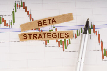 On the chart of business quotes lies a pen and torn paper with the inscription - Beta Strategies
