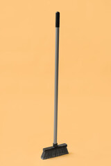 Broom for cleaning on orange background