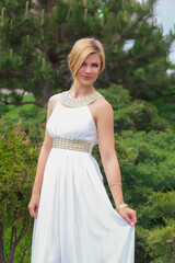 blonde beautiful natural girl with blonde hair in a white dress in nature, on the street, in the garden by a tree, with makeup and hairstyle, greek woman in a white ethnic historical dress, retro