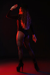 Attractive female dancer in high heels on dark background