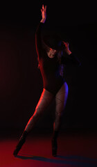 Attractive female dancer in high heels on dark background