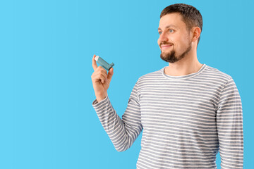 Man with inhaler on blue background
