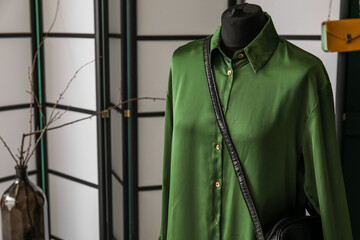 Mannequin with green dress and bag in fashion designer's studio, closeup