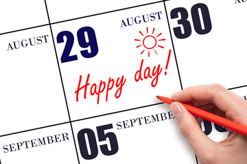 Hand writing the text HAPPY DAY and drawing the sun on the calendar date August 29