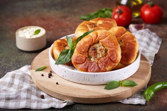 Peremech or belyash pies from yeast dough with grounded meat.  Street food. Savory snack. Delicious homemade appetizer. Open pie and filling is visible in the middle.