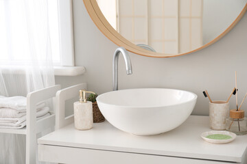 Fototapeta na wymiar Interior of bathroom with sink, mirror and bath accessories