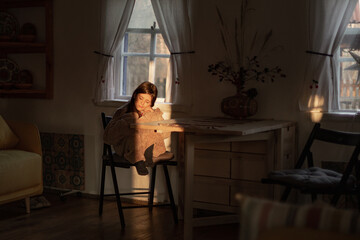 a little girl sits in an authentic house in a Ukrainian village