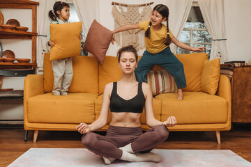 Mom woman meditates and concentrates to the noise and games of children