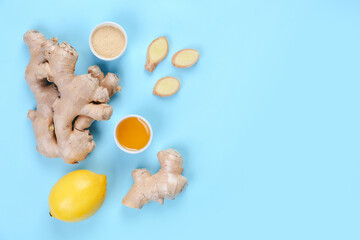 Ginger roots, powder, lemon and bowl of honey on blue background