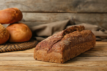 Loaf of fresh rye bread on wooden table