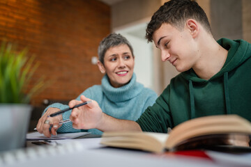 One student teenage caucasian man study learn with help of his tutor professor or mother senior...