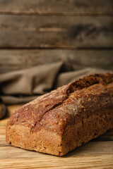 Loaf of fresh rye bread on wooden table