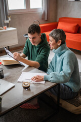 One student teenage caucasian man study learn with help of his tutor professor or mother senior...