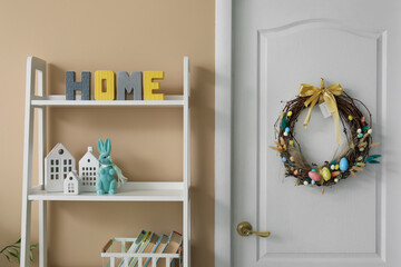 Easter wreath hanging on white door in room