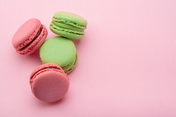Colorful french macarons isolated on pink background.