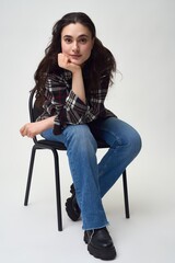 Fototapeta premium Stylish woman sitting on chair and looking at camera
