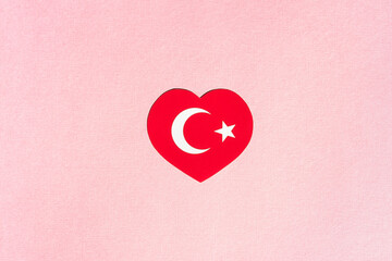 Turkey flag in the shape of a heart on a pink background.