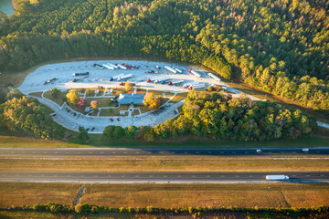 View from above of big parking rest area for cars and trucks near busy american highway with fast...