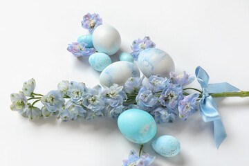 Composition with painted Easter eggs and beautiful flowers on white background