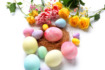 Fototapeta na wymiar Composition with painted Easter eggs and flowers on white background, closeup