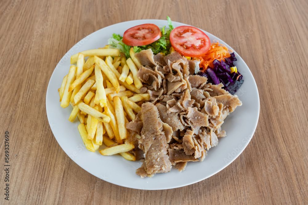 Wall mural Kebab on a plate with fried potato salad and vegetables.