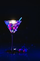 Martini glass and olives on a black background with neon lights