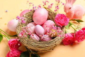 Fototapeta na wymiar Nest with painted Easter eggs and beautiful flowers on color background, closeup