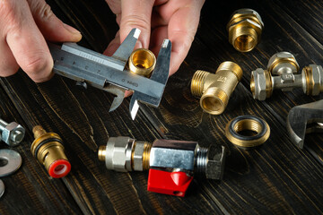 Repair of plumbing equipment on the table in the workshop by the hands of the master. Copy space....