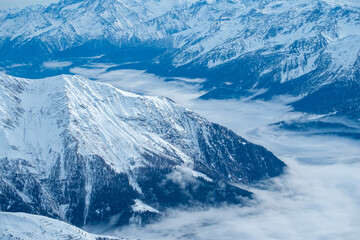 Mountains covered with snow and clouds. The mountains are the Italian Alps