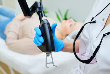 cosmetologist uses a CO2 fractional ablative laser to rejuvenate the skin and remove scars in a modern cosmetic beauty clinic.