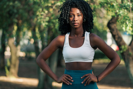 retrato de mujer negra con ropa deportiva, preparándose para hacer ejercicios en un parque con luz natural. concentrada para hacer deporte.