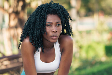 bella mujer afroamericana respirando después de hacer ejercicios al aire libre en un parque. calma, meditación, bienestar, ejercicios y yoga. mujer practicando deportes en la naturaleza.