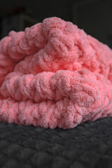 Knitted blanket. Homemade plush plaid. Gentle yarn. Scandinavian style. Warm clothes. Hygge in the interior.