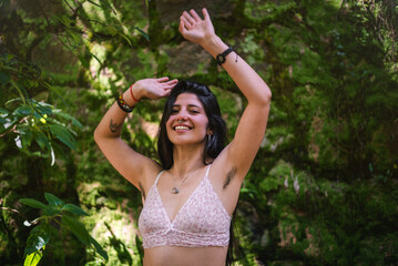 Happy young woman showing her armpit hair in the nature - obrazy, fototapety, plakaty
